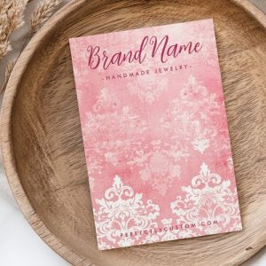 Pink and white damask patterned earring display card with customizable branding.