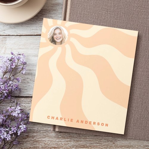 Custom retro notepad with orange and yellow sunburst rays, round photo frame at the top left, and personalized name text in bold orange letters at the bottom. Great for gifts